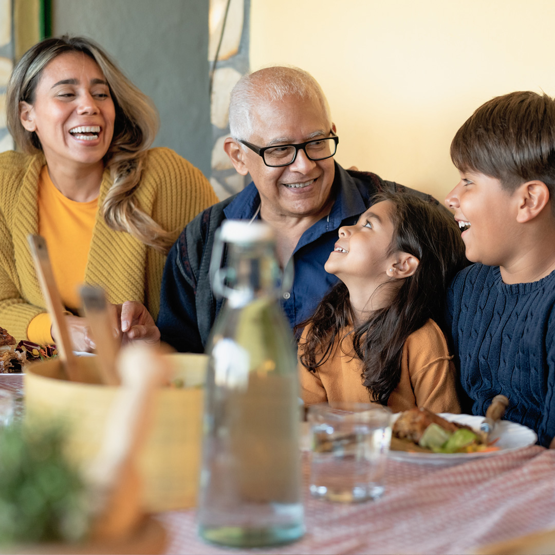 multigenerational family talking and laughing at the dinner table