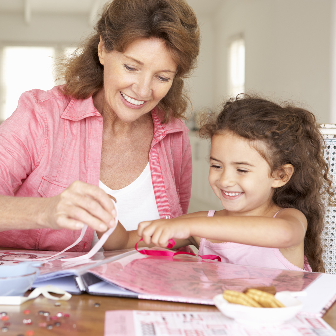 grandmother and granddaughter working on a scrapbook together